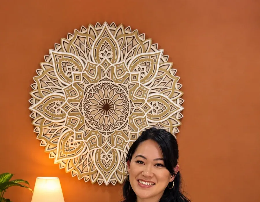 Thassiana Harumi na sala de atendimento, com a mandala e a luz baixa